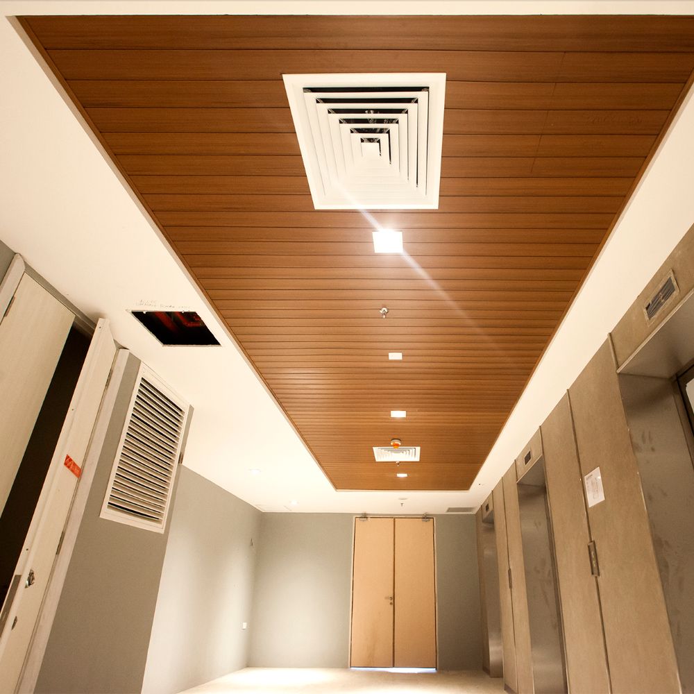 Lam gỗ phòng khách sử dụng để trang trí trần nhà cùng hệ thống đèn thả trần lung linh
