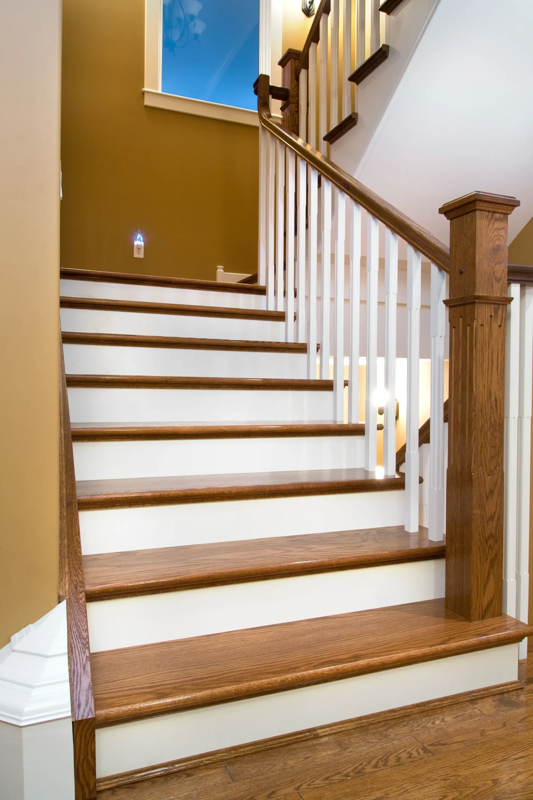 Mẫu cầu thang gỗ vuông phối với bậc cầu thang màu nâu gỗ và màu trắng