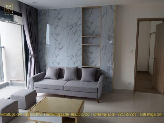 Phòng khách được thi công nổi bật với vách tường bằng đá Marble vân mây kết hợp kệ để đồ tiện nghi