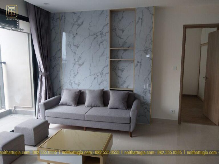 Phòng khách được thi công nổi bật với vách tường bằng đá Marble vân mây kết hợp kệ để đồ tiện nghi
