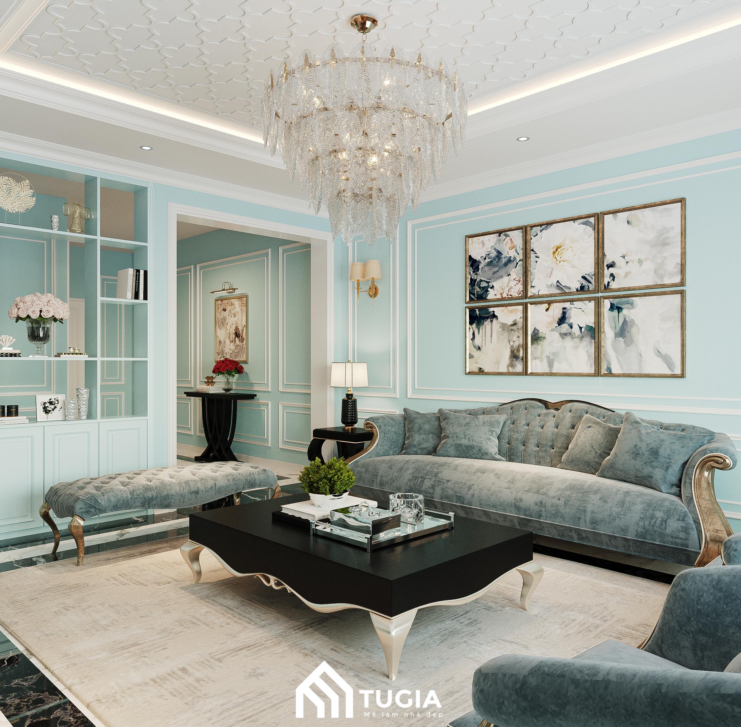 Phòng khách nhà phố Tân Cổ Điển với bộ sofa bọc vải màu xanh dương, bàn trà bằng đá và đèn chùm pha lê
