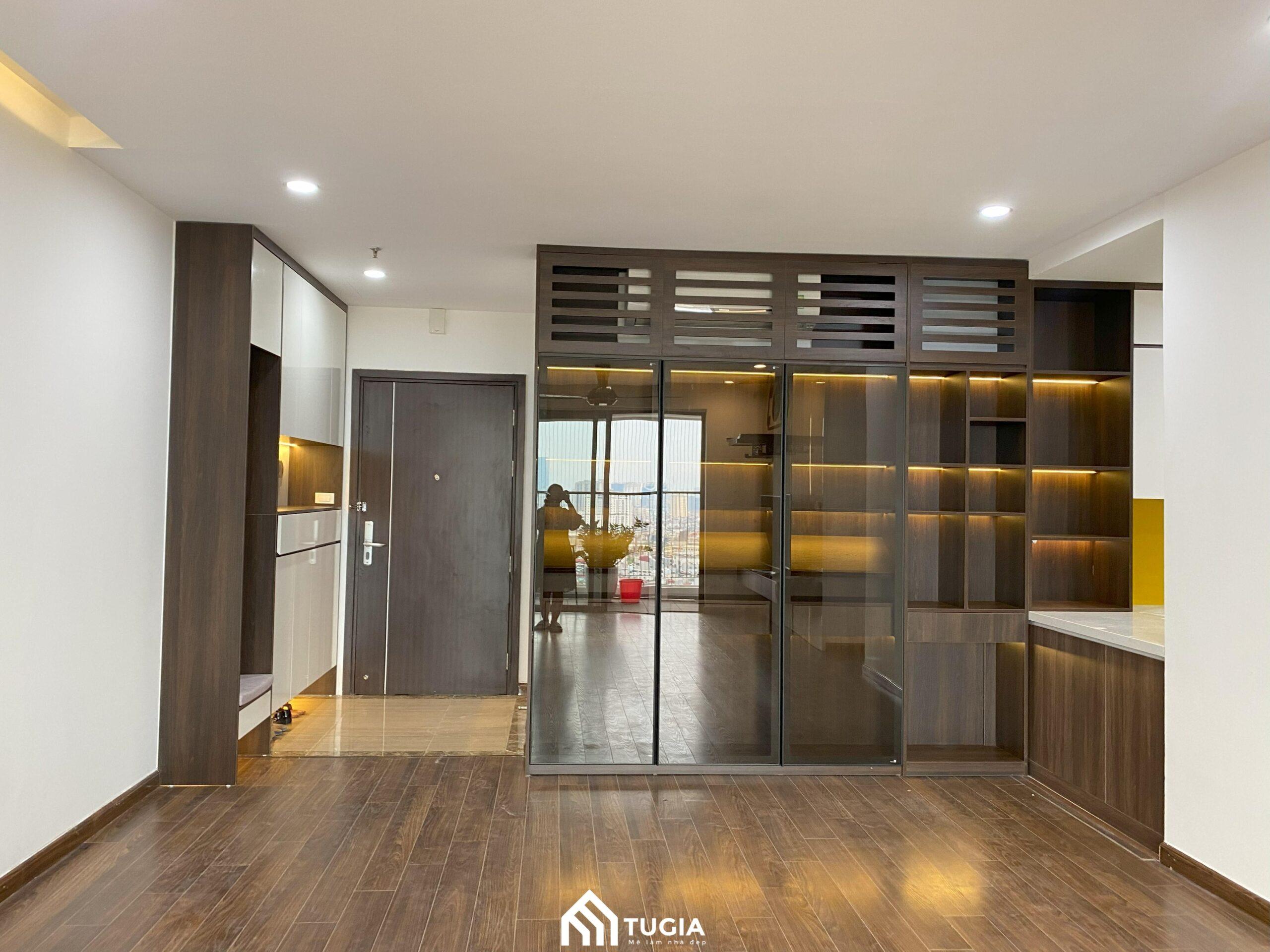 Sàn gỗ màu trầm kết hợp với cửa kính lớn, mang đến cảm giác ấm áp và thông thoáng