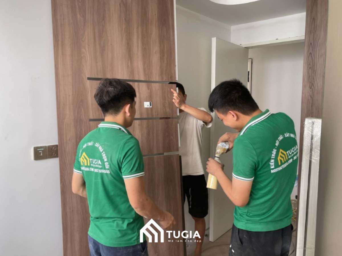 Đội ngũ thợ Nội Thất Tứ Gia thi công lắp đặt cửa gỗ thực tế tại công trình